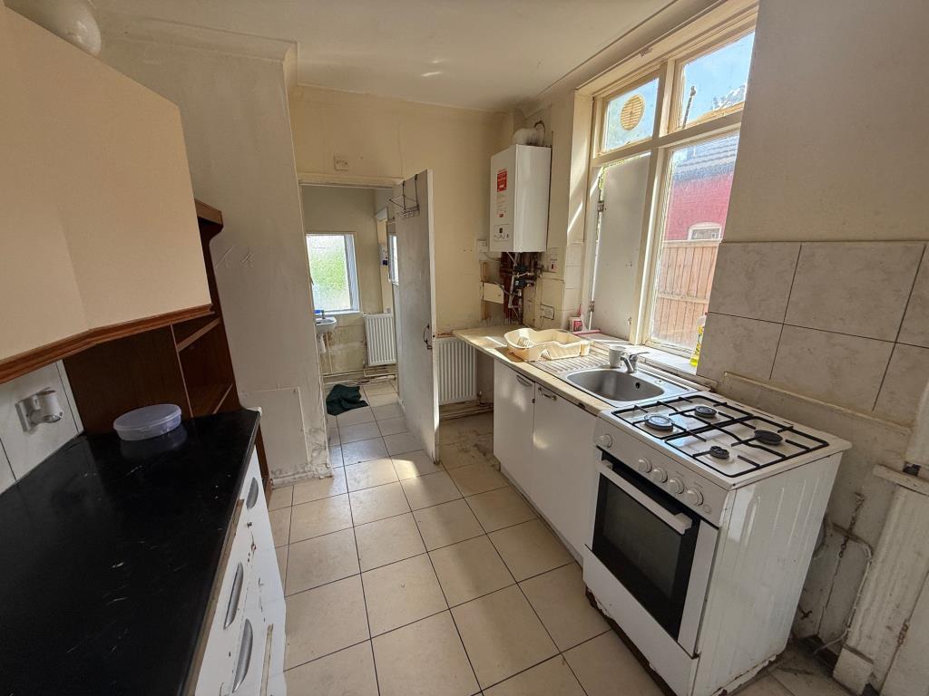 Lot: 103 - THREE-BEDROOM MID-TERRACE HOUSE REQUIRING IMPROVEMENT - Basic kitchen area with access to bathroom